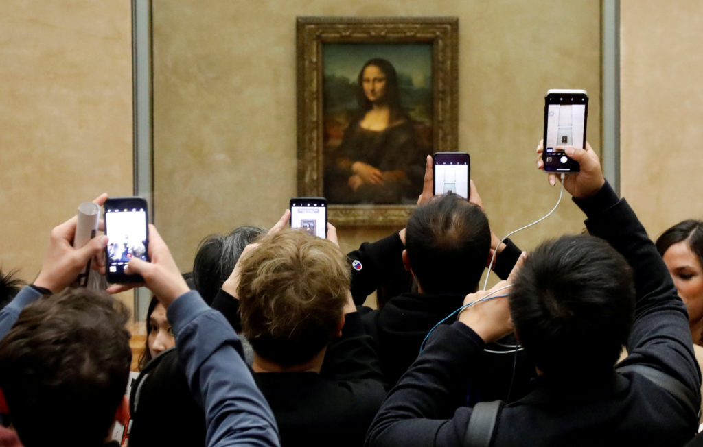 FILE PHOTO: Visitors take pictures of the painting "Mona Lisa" by Leonardo Da Vinci at the Louvre museum in Paris