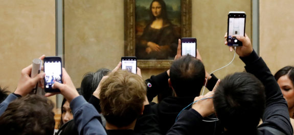FILE PHOTO: Visitors take pictures of the painting "Mona Lisa" by Leonardo Da Vinci at the Louvre museum in Paris