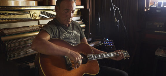 Bruce Springsteen tocando la guitarra en su casa.