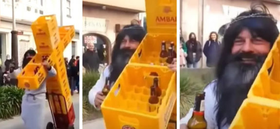 Hombre carga una cruz hecha con cajas de cerveza