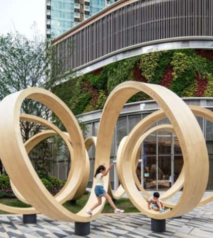 Instalación de madera en forma de bucle invita al público a descansar